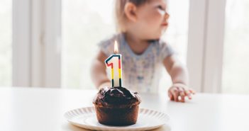 Quel cadeau offrir pour un premier anniversaire ? Enfant qui souffle sa première bougie d'anniversaire