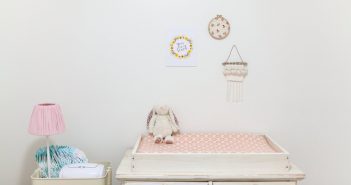 Les 5 articles indispensables pour la chambre de bébé Table à langer avec une peluche installée dans une chambre de bébé