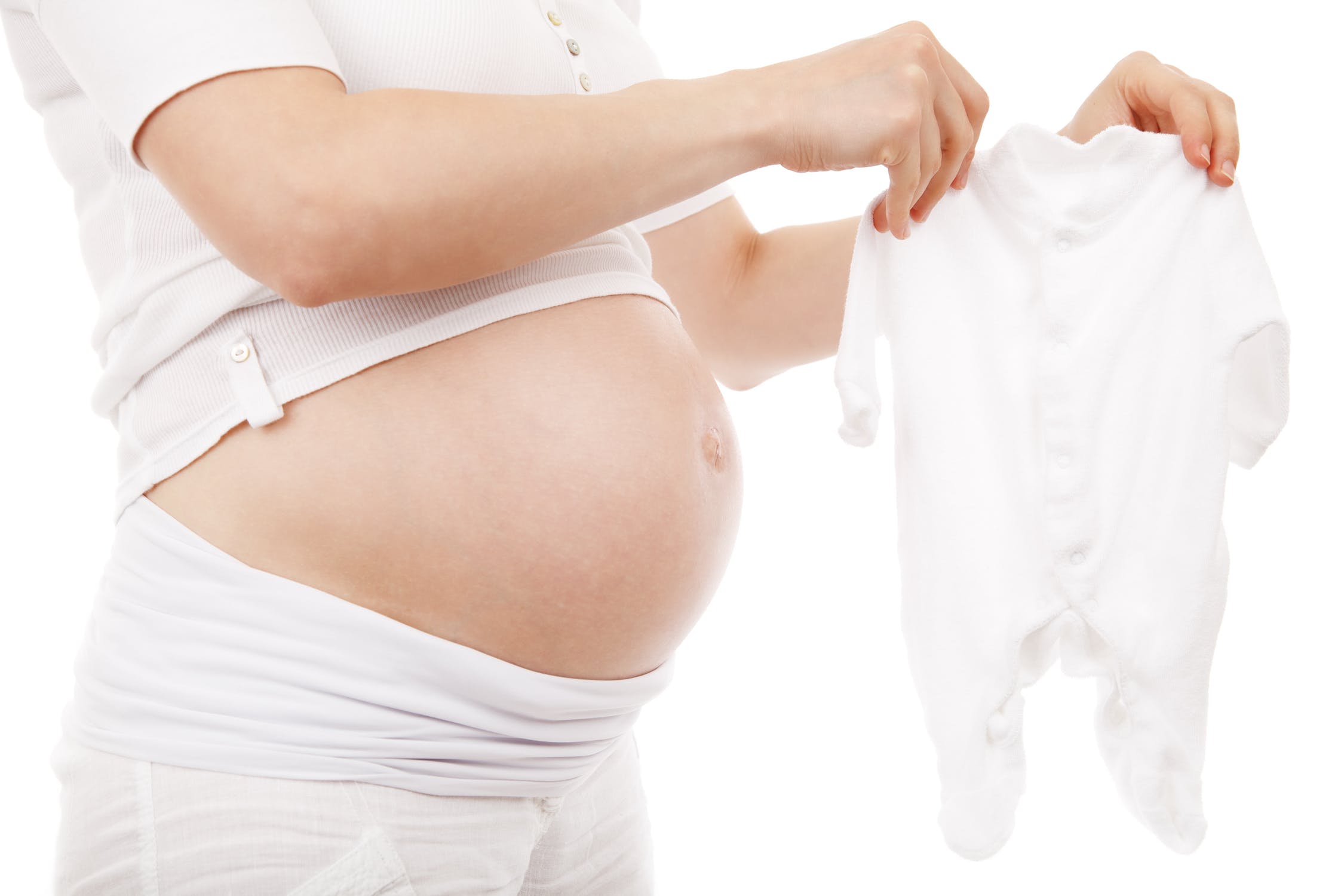 Femme enceinte qui choisit un pyjama pour le trousseau de naissance de son bébé