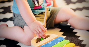 Les jouets incontournables à offrir à son bébé Enfant qui joue avec un xylophone en bois