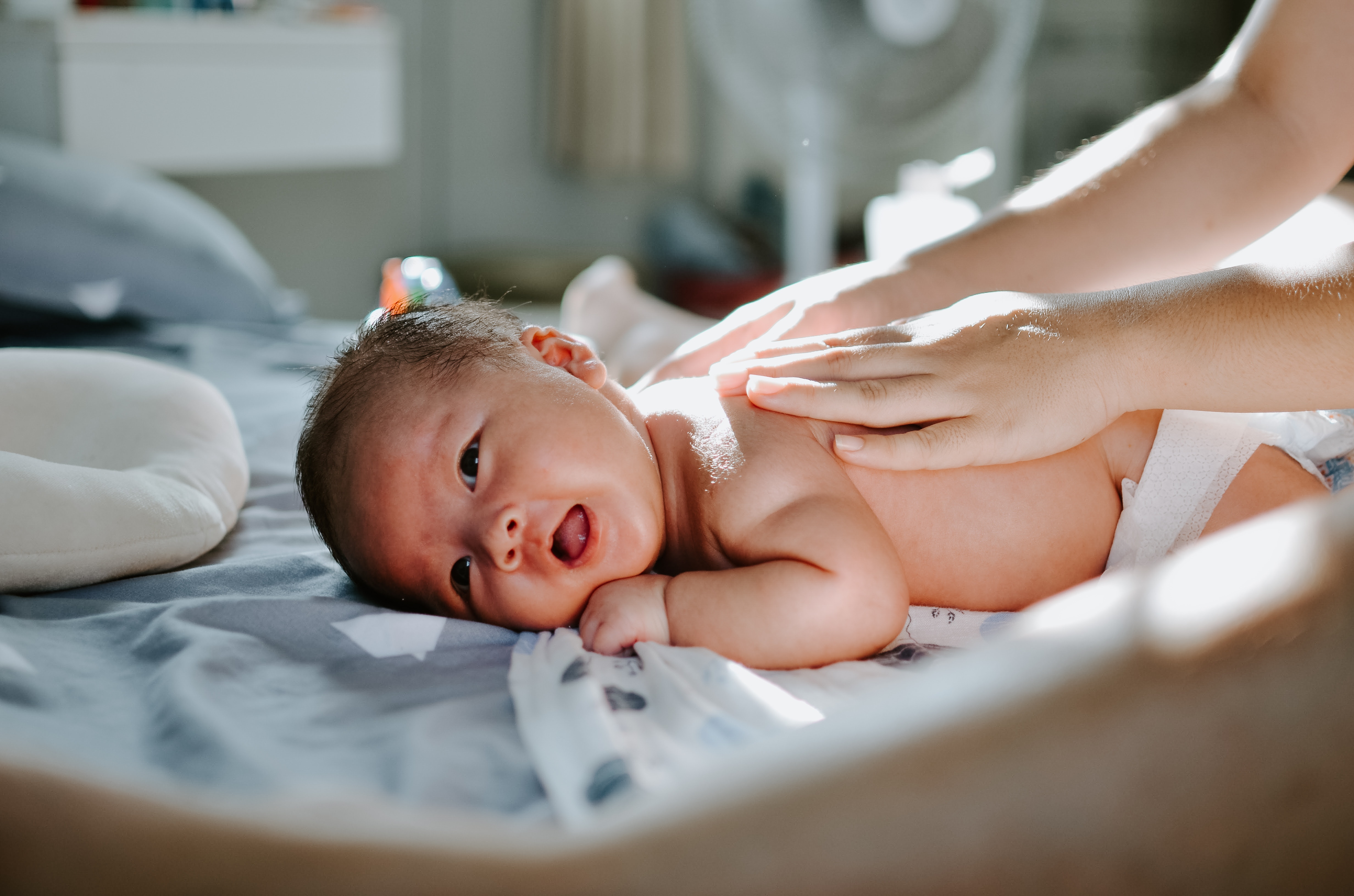 Maman qui masse le dos de son bébé