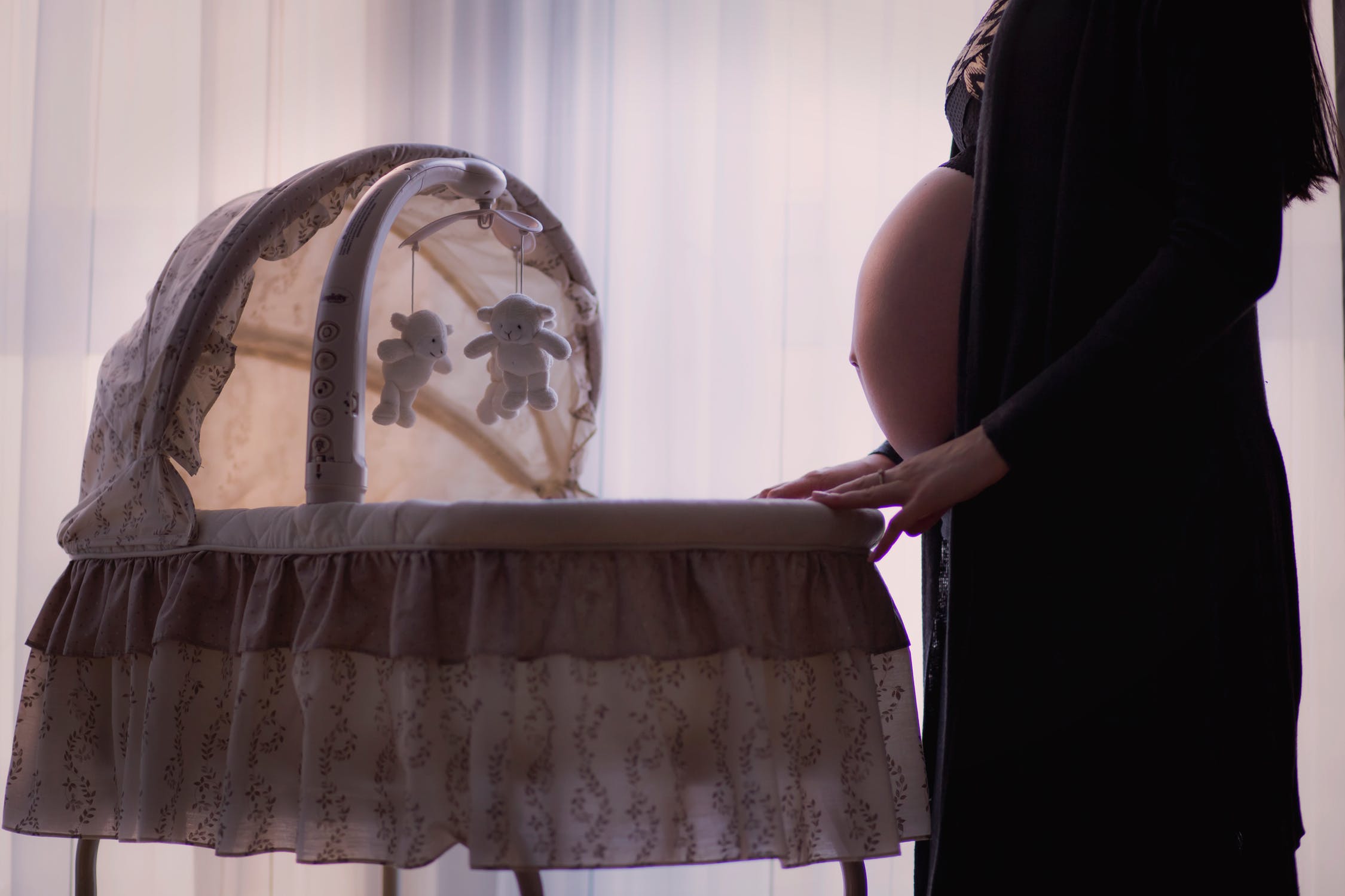 Femme enceinte qui prépare le berceau pour l'arrivée de son bébé